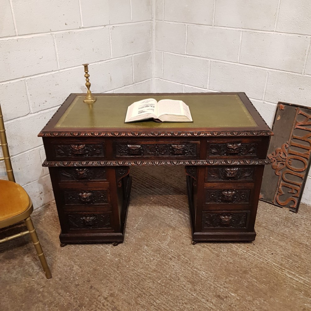 a victorian green man carved oak twin pedestal desk c1880