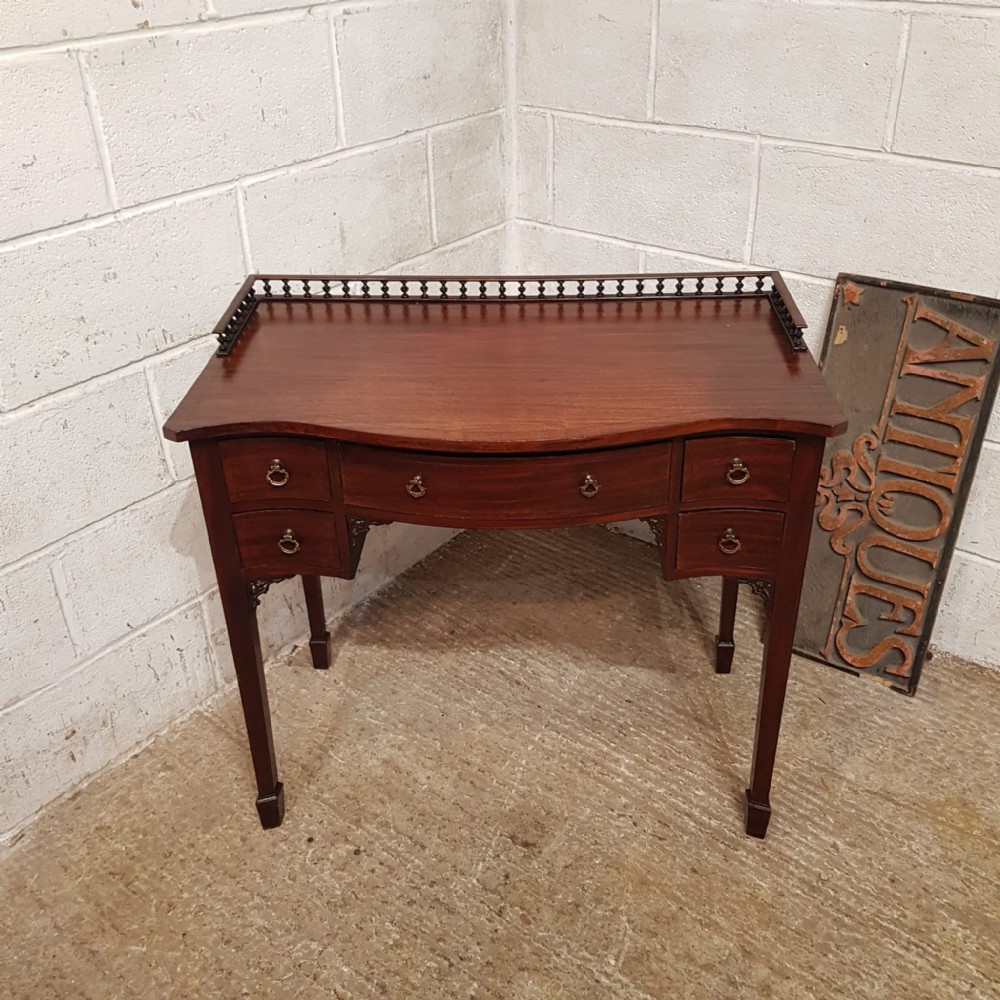 an edwardian serpentine fronted mahogany writing table c1900